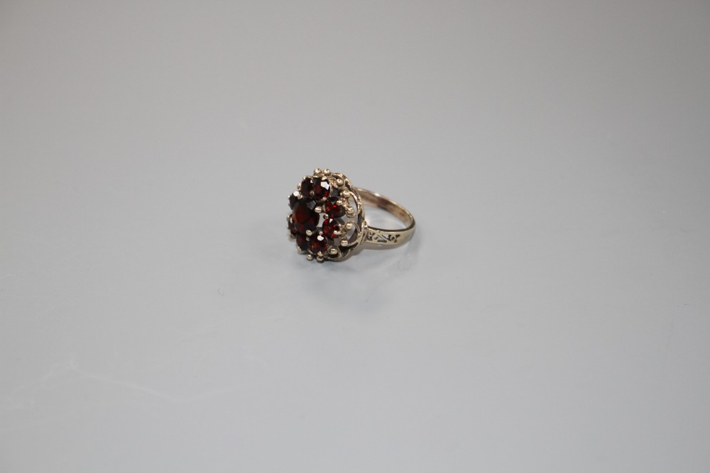 A 14k yellow metal and nine stone garnet cluster dress ring, size O, gross weight 5.6 grams.